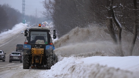 Tractors of Road Service Clean Up the Snow from the Roadside