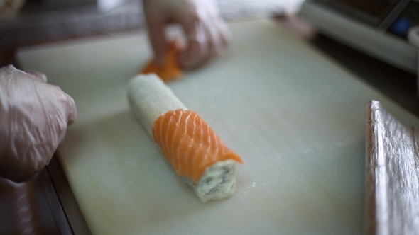 A Sushi Chef Prepares Rolls Using a Bamboo Mat