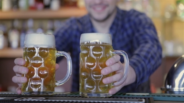 Bartender Holding Beer Glasses And Smiling