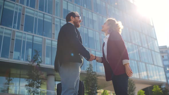 Low Angle View of Business Colleagues Greeting Each Other with Handshake Standing Outdoors