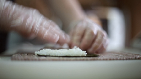 A Sushi Chef Prepares Rolls Using a Bamboo Mat
