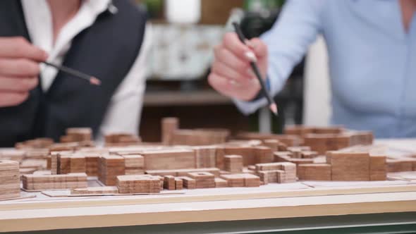 Close Up of Architects Over Miniature Town