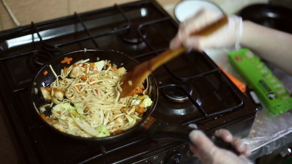 Noodles with Meat and Vegetables are Fried in the Frying Pan