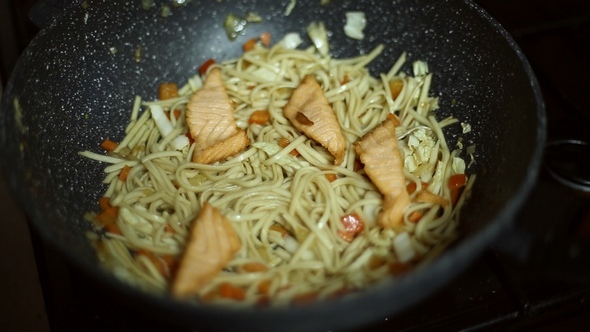 Noodles With Red Fish and Vegetables are Fried in the Pan