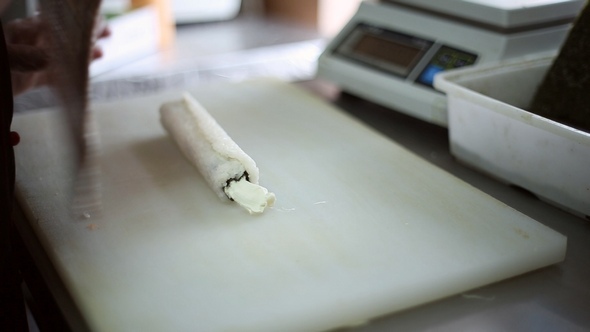 A Sushi Chef Prepares Rolls using a Bamboo Mat