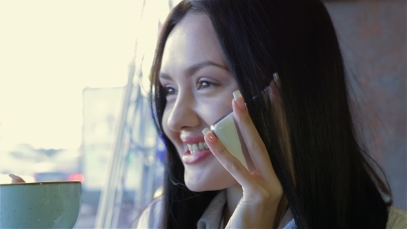 Woman Talking On The Phone In Cafe