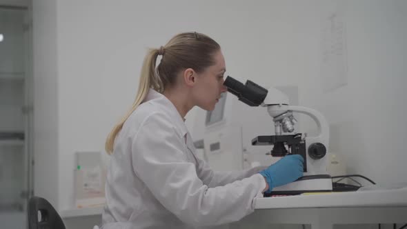 Female Scientist Using Microscope While Working in Laboratory