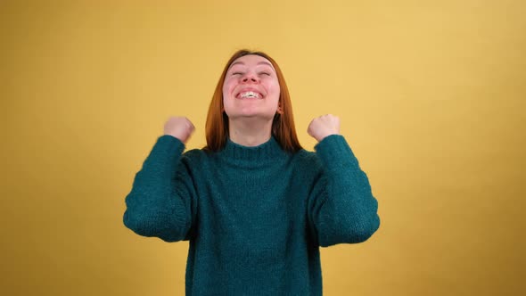 Young Red Hair Woman in Green Sweater Posing Isolated on Yellow Color Background Studio