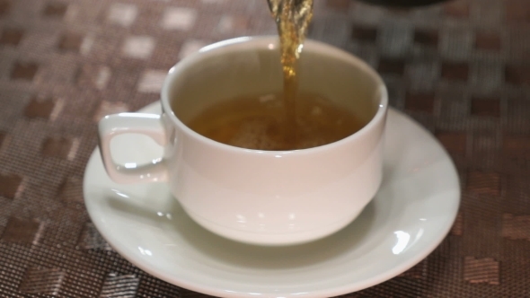 Pouring Black Tea In a White Porcelain Mug