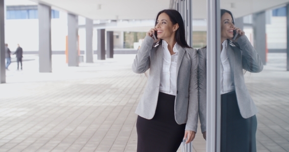 Smiling Gorgeous Woman On Phone Outside Office alt
