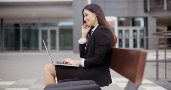 Woman Looking Over With Laptop On Bench