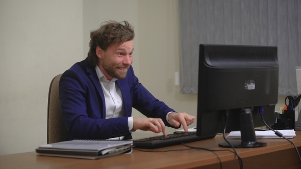 ceActive Businessman Rejoices Success in The Office, Sitting at The Computer