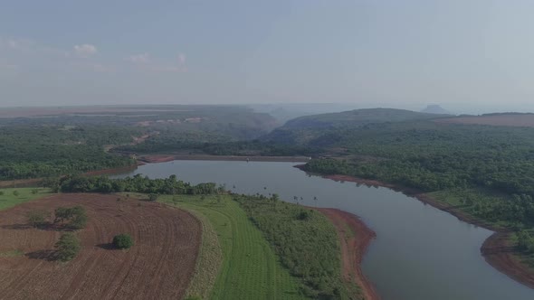River and dam in Brazil among forest and crop fields