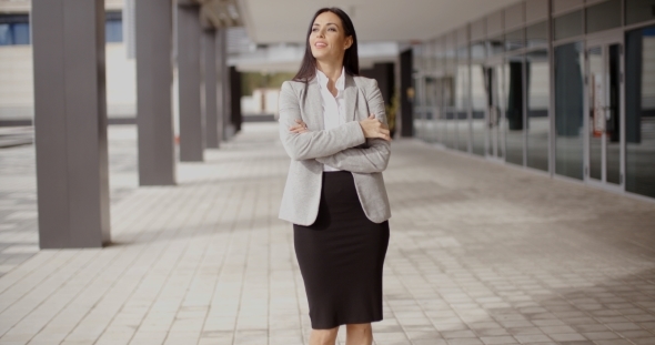 Hopeful Woman With Folded Arms Near Building alt