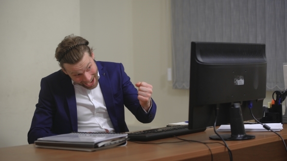 Active Businessman Rejoices Success. In The Office, Sitting At The Computer