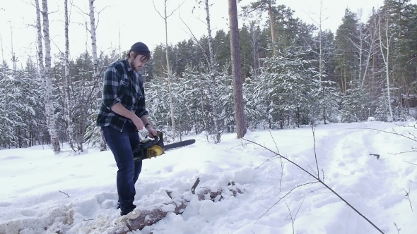 Lumberjack Chainsaw Manual Sawing Wood In The Winter Snowy Forest