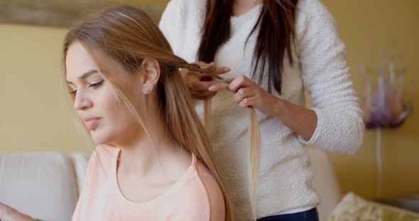 Pretty Woman With a Friend Fixing Her Blond Hair