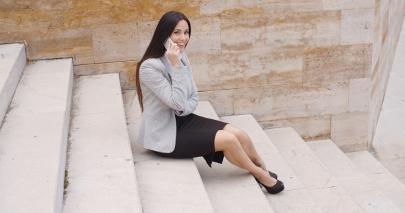 Cute Business Woman Sitting On Steps With Phone