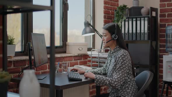 Worker at Customer Service Using Microphone on Phone Call