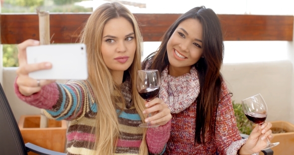 Two Girls Taking Selfie While Holding Wine alt