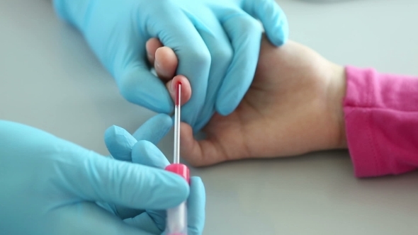 Nurse Takes Blood From a Finger Of Child In Medical Laboratory.