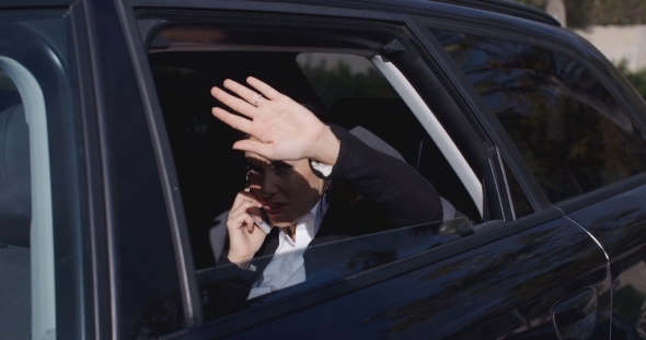 Executive In Car Blocking View From Window alt