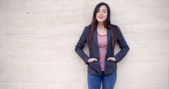 Trendy Young Woman Posing Against a Wall