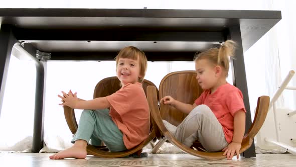 Happy Siblings Playing Under Table