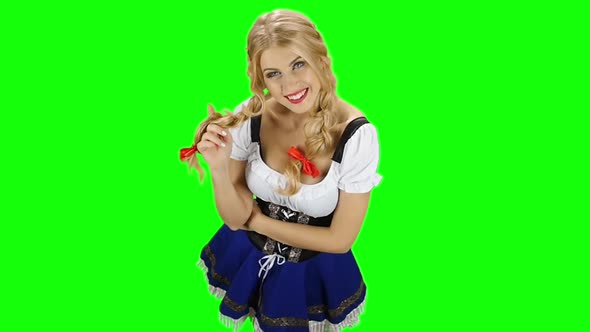 Girl in Bavarian Costume Playing with Her Hair and Laughs. Green Screen