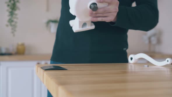 Man Installs Home Flour Mill on Wooden Table Close View