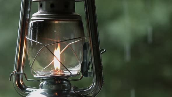 Old Lantern Hanging Outside and Rain Falling from Cottage Roof