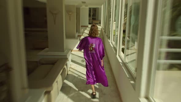 a Young Woman in a Purple Silk Vintage Kimono is Walking Through the Hotel