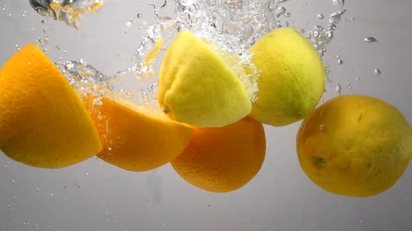 Lemon and Orange Drops Into Water in Slow Motion