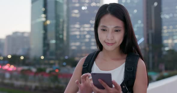 Woman work on mobile phone in city at evening time