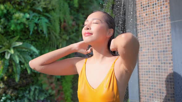 Young asian woman enjoy around outdoor swimming pool for leisure