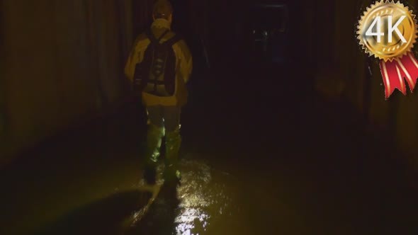 Backpacker in Gumboots is Walking by Water