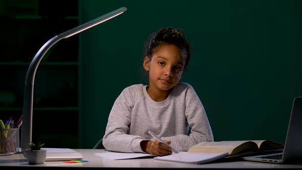 The Girl Looks Thoughtfully Into the Camera and Releases the Pen From Her Hands