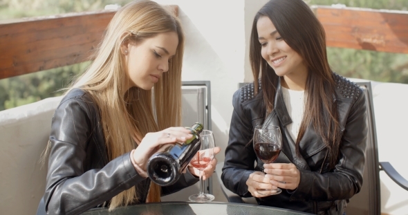 Friend Pouring Woman Wine At Table alt