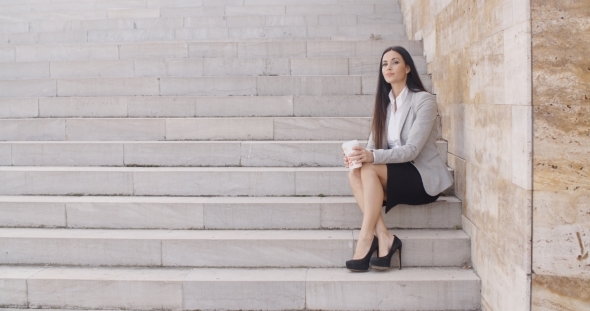 Serious Woman Sitting On Stairs Outdoors