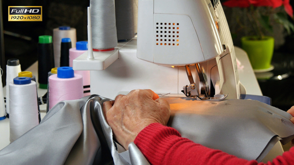 Seamstress Sews Clothes with her Over Lock Machine