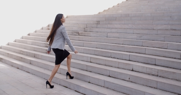 Serious Woman Walking Up Staircase
