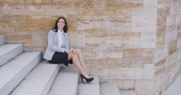 Serious Woman Sitting On Stairs Outdoors