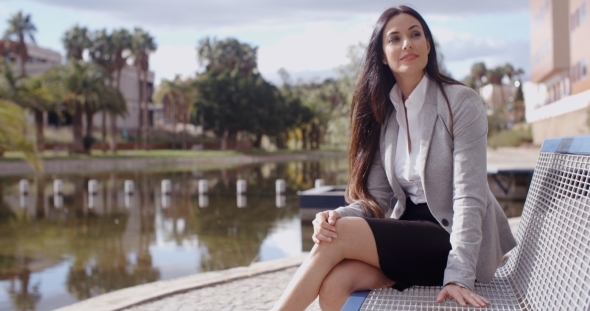 Business Woman Sitting On Bench Looking Away