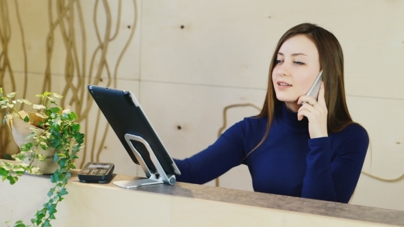A Young Woman Working At The Reception Or The Hotel Company