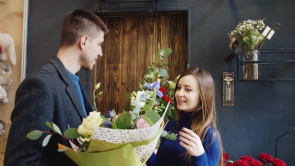 The Young Man Chooses a Bouquet At a Flower Shop