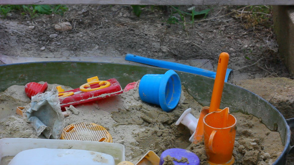 Child Playing With Plastic Toys In Sandbox