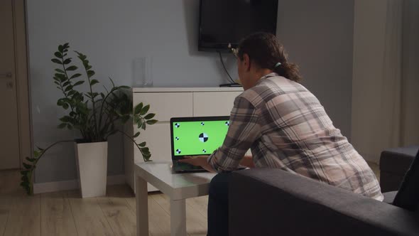 Moving Shot of Adult Female Using Laptop with Chroma Key Mockup Indoor