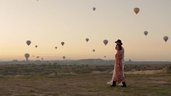 Stylish Couple Walking To The Air Balloons. The Feeling Of Complete Freedom