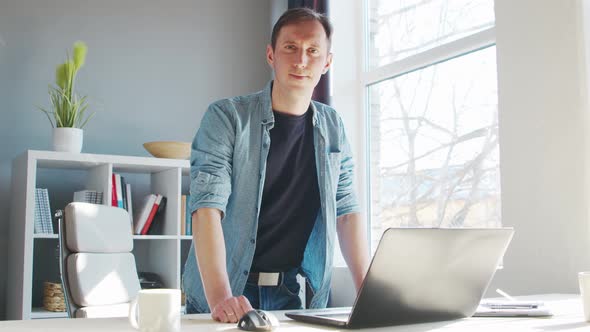 Young male entrepreneur works at home office at the computer.