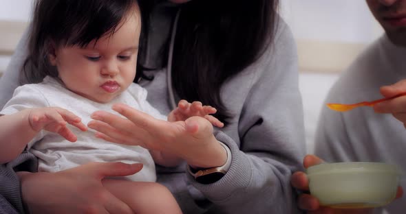 Young Parents Give Healthy Food to Baby Baby's First Food